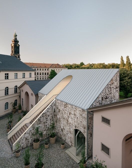 Modernistischer Gebäudekomplex mit markantem Kirchturm und geometrischen Formen